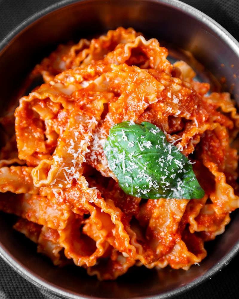 Manfredi con ricotta: pasta larga ondulada con salsa de tomate, ricotta y albahaca