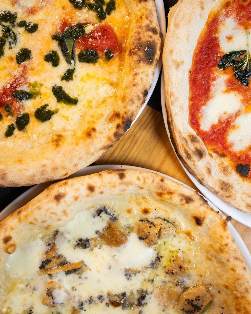 Tres pizzas napolitanas vistas desde arriba, sobre la mesa