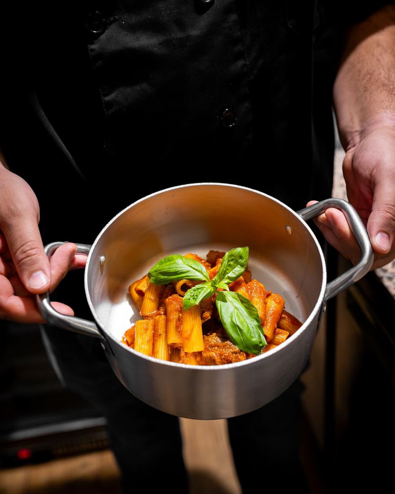 Rigatoni al ragú napolitano en su cazo, con albahaca fresca